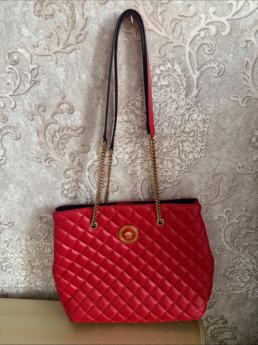 Quilted Red Tote Bag with Gold Emblem and Chain Straps